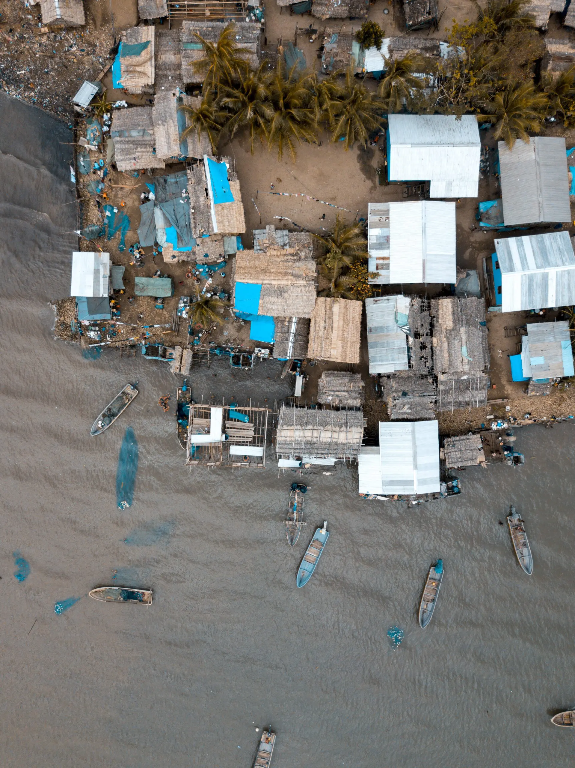 An aerial vertical shot of buildings near the sea with boats